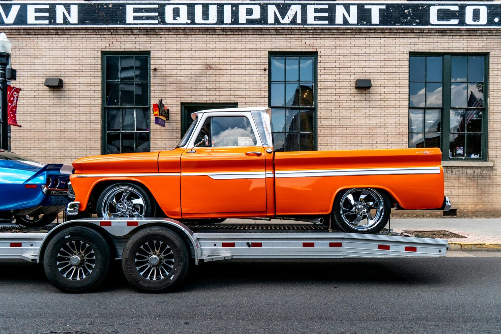 Classic orange pickup truck on trailer in front of brick building, Bristol, Tennessee.